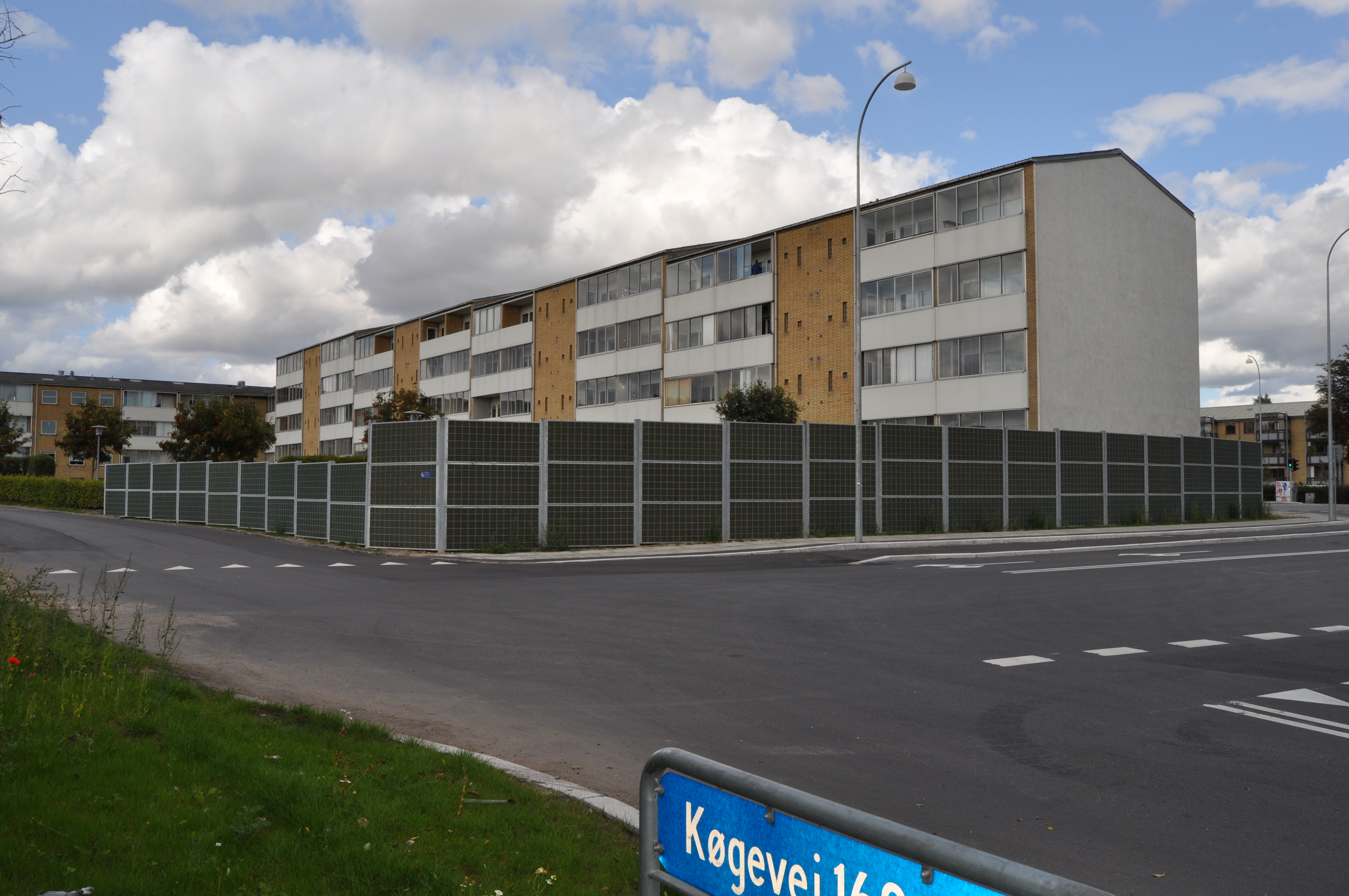 Ein Noistop® Steel-Lärmschutzzaun von Poda Zaun zur Abschirmung von Verkehrslärm an einem Wohngebäude